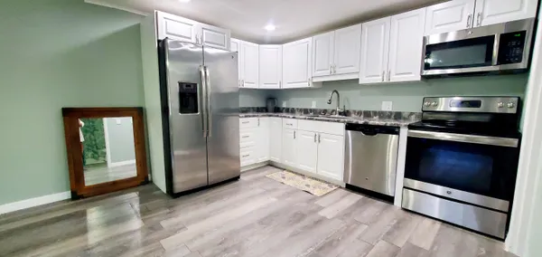 a kitchen with stainless steel appliances granite countertop a stove a refrigerator and a microwave