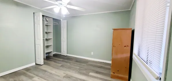 an empty room with closet and a ceiling fan