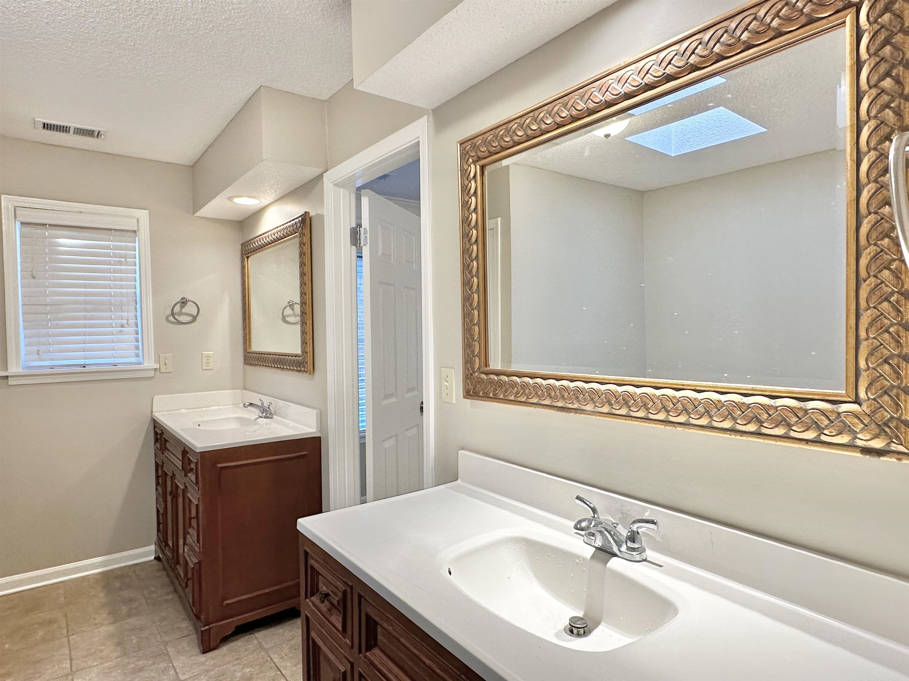 7475 Kingsland Drive Memphis, TN 38125 - Photo 14 of 32 a bathroom with a sink and a mirror
