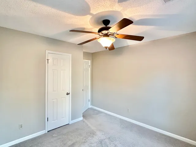 an empty room with chandelier fan