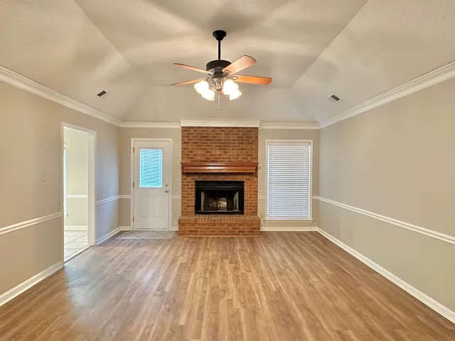 a view of an empty room with a window and a fireplace