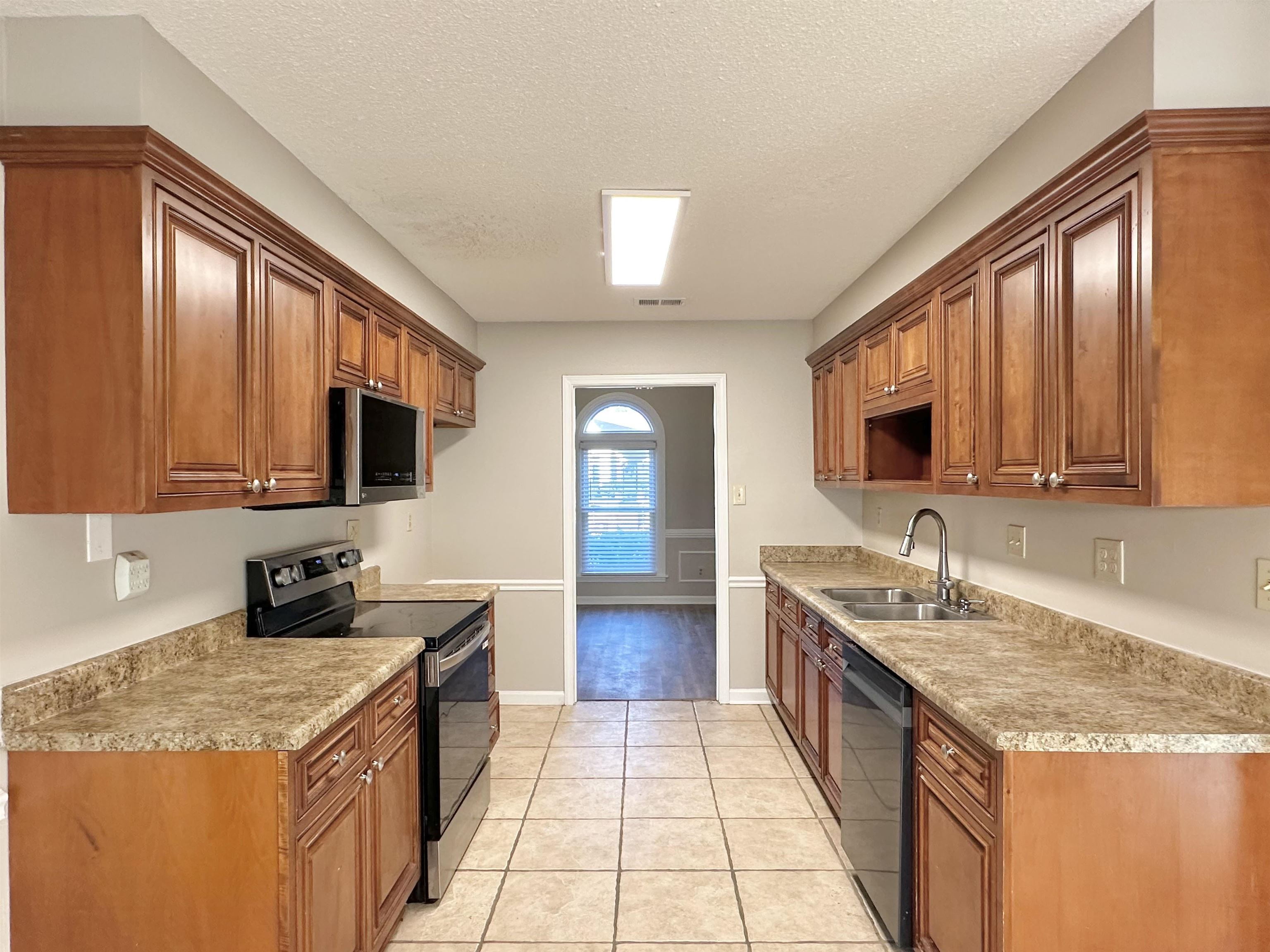 7475 Kingsland Drive Memphis, TN 38125 - Photo 6 of 32 a kitchen with granite countertop stainless steel appliances a sink stove top oven and cabinets