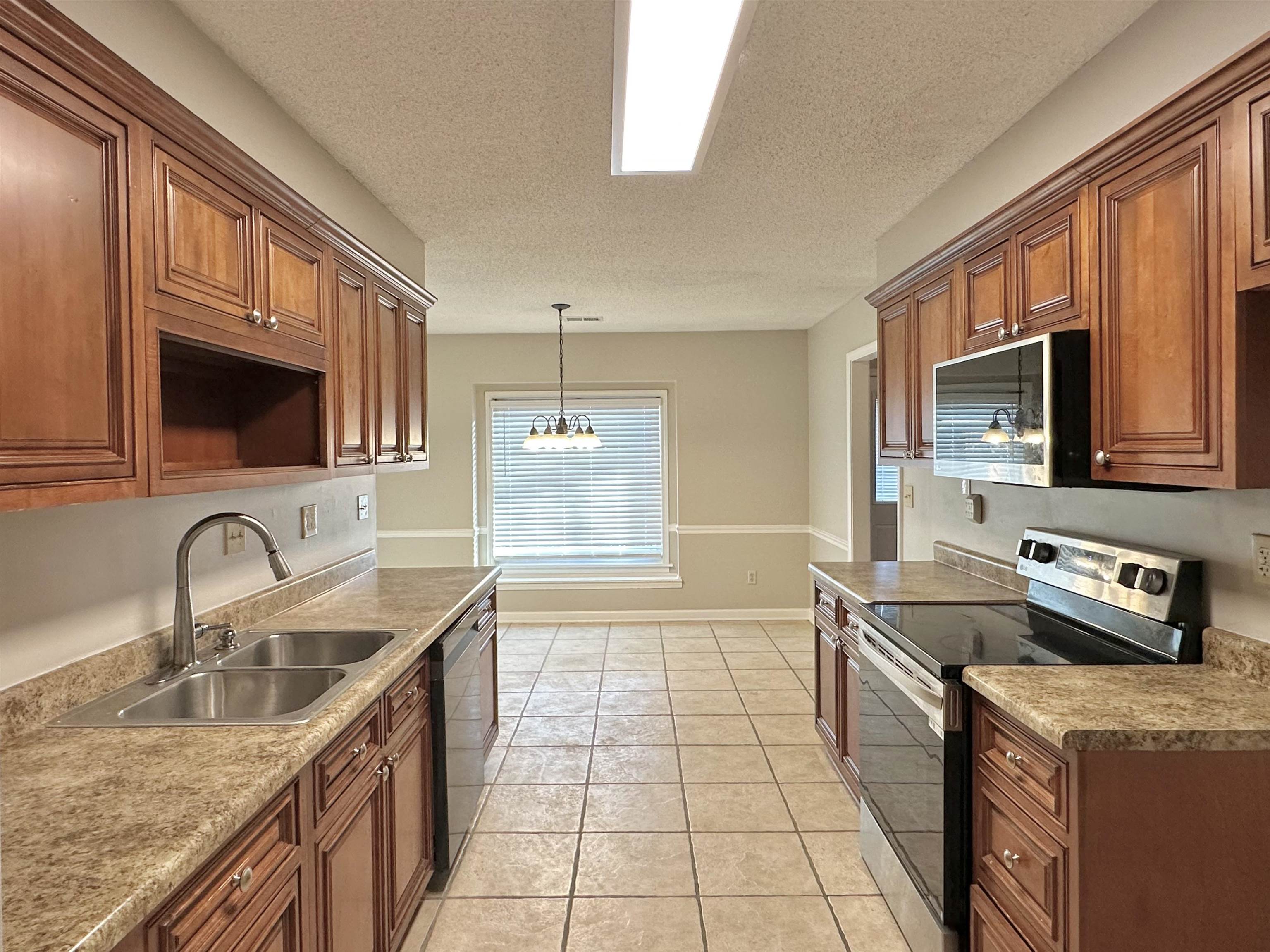 7475 Kingsland Drive Memphis, TN 38125 - Photo 7 of 32 a kitchen with stainless steel appliances granite countertop a sink stove and cabinets