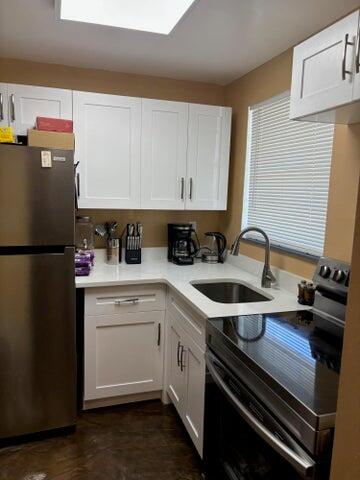 2475 West Golf Boulevard, Unit 145 Pompano Beach, FL 33064 - Photo 2 of 7 a kitchen with a sink appliances and cabinets