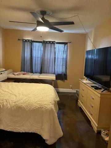 a bed sitting in a spacious bedroom next to a window