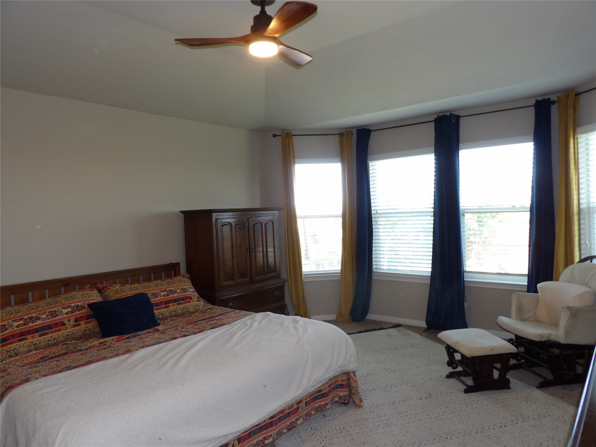 930 Pumpkin Ridge New Braunfels, TX 78130 - Photo 19 of 32 Recessed tray ceiling with a wood-finish ceiling fan, multiple bay windows with blinds, and neutral wall tones