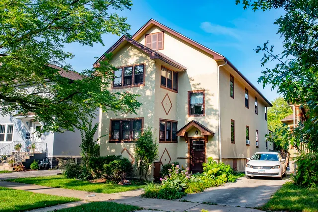 a front view of a house with a yard and trees
