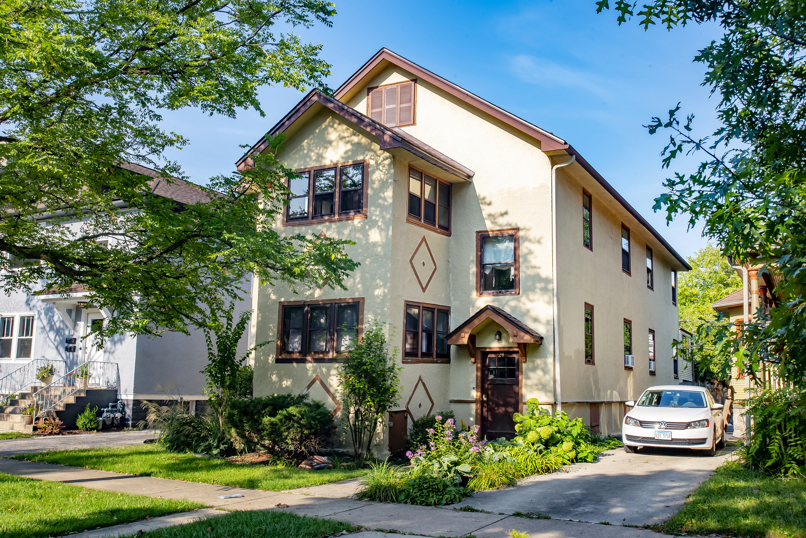 a front view of a house with a yard and trees