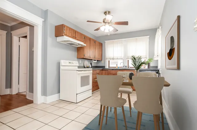 a dining room with furniture a kitchen a sink and a chandelier