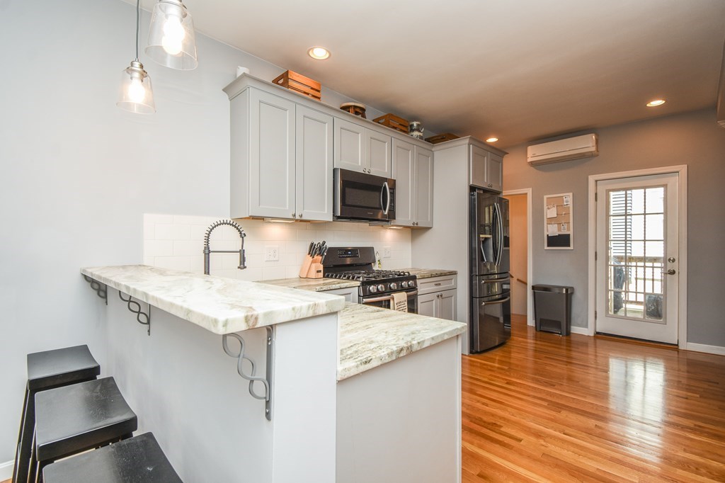a kitchen with stainless steel appliances granite countertop a sink stove refrigerator and wooden floor