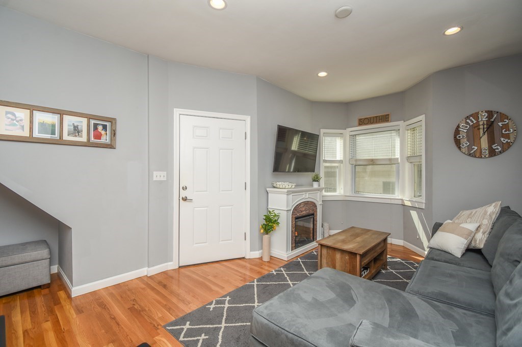 266 Bowen Street, Unit 1 Boston, MA 02127 - Photo 14 of 33 a living room with furniture a fireplace and a flat screen tv