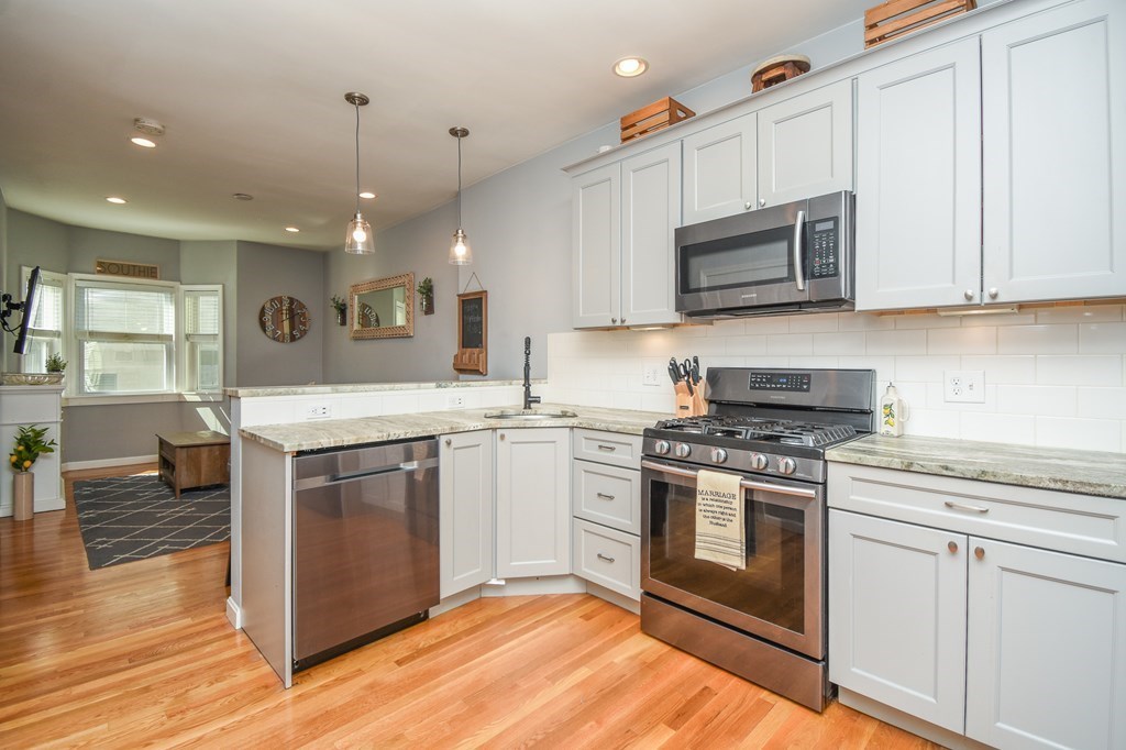 266 Bowen Street, Unit 1 Boston, MA 02127 - Photo 3 of 33 a kitchen with stainless steel appliances granite countertop a stove a sink and a microwave