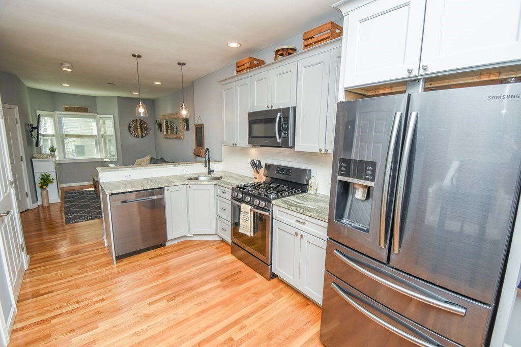 266 Bowen Street, Unit 1 Boston, MA 02127 - Photo 5 of 33 a kitchen with stainless steel appliances and white cabinets