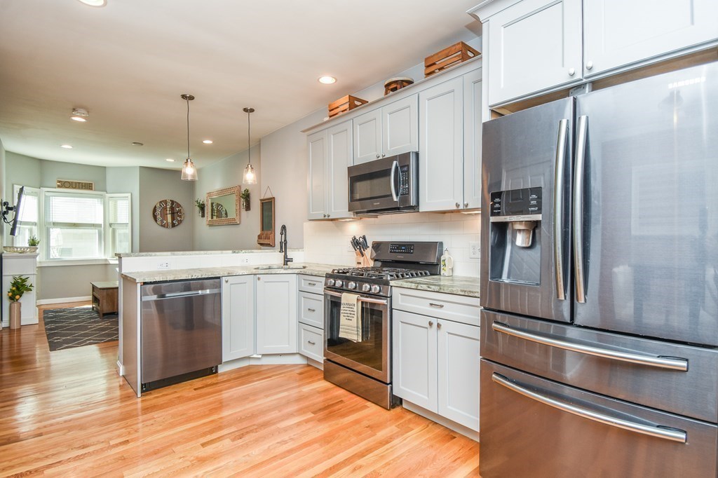 266 Bowen Street, Unit 1 Boston, MA 02127 - Photo 9 of 33 a kitchen with kitchen island a counter top space stainless steel appliances and cabinets