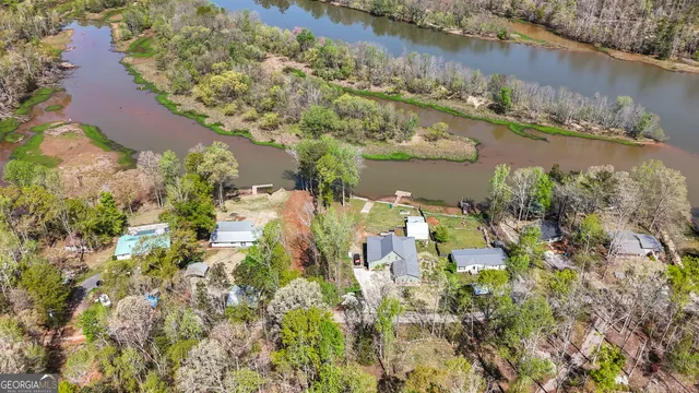 an aerial view of residential houses with outdoor space and lake view