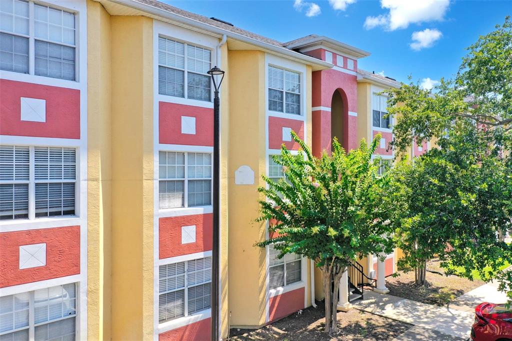 3502 Windy Walk Way, Unit 2105 Orlando, FL 32837 - Photo 1 of 1 a front view of multi story residential apartment building with yard