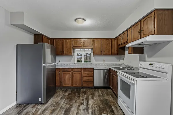 a kitchen with stainless steel appliances granite countertop a stove a sink dishwasher and a refrigerator