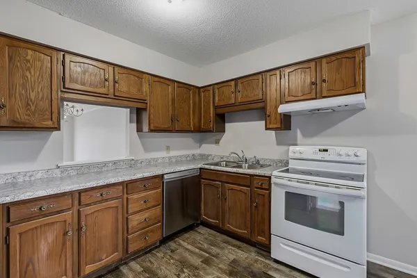 a kitchen with granite countertop cabinets stainless steel appliances and sink