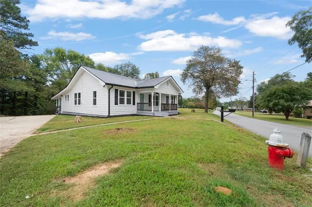 a view of a house with pool and a yard