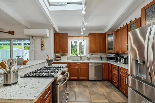 a kitchen with stainless steel appliances granite countertop a sink stove and refrigerator
