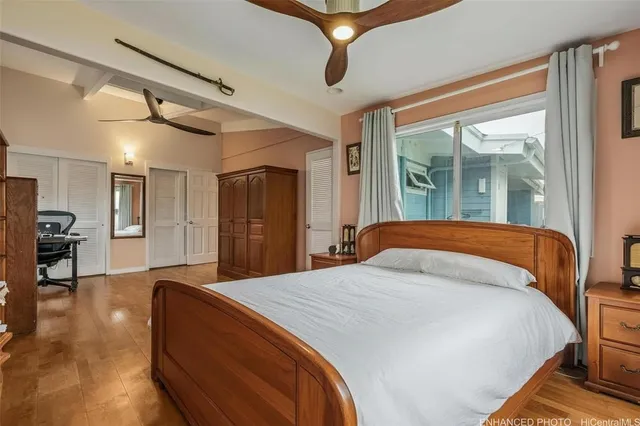 a bed sitting in a spacious bedroom next to a window