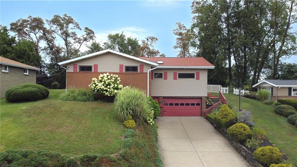 a view of a house with a yard and large trees
