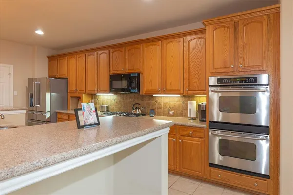 a kitchen with granite countertop a stove top oven microwave and cabinets