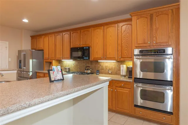 a kitchen with granite countertop a stove top oven microwave and cabinets