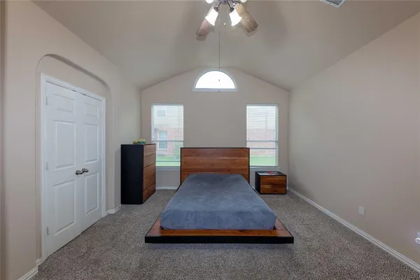 a spacious bedroom with a bed and a chandelier