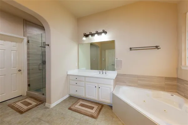 a bathroom with a tub sink and mirror