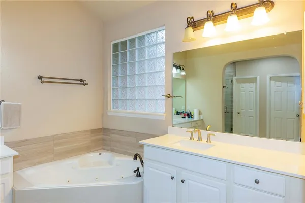 a bathroom with a tub sink and mirror