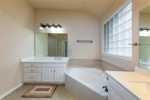 a bathroom with a tub sink and mirror