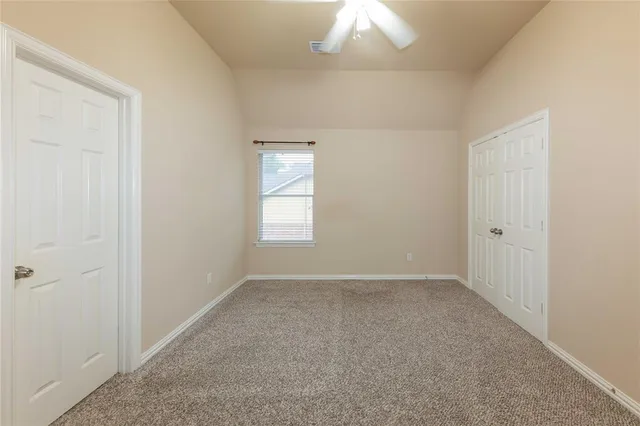 an empty room with a chandelier fan