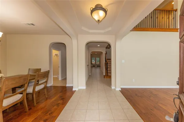 a view of a hallway with wooden floor windows a chandelier and entryway