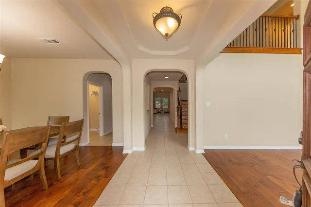 a view of a hallway with wooden floor windows a chandelier and entryway