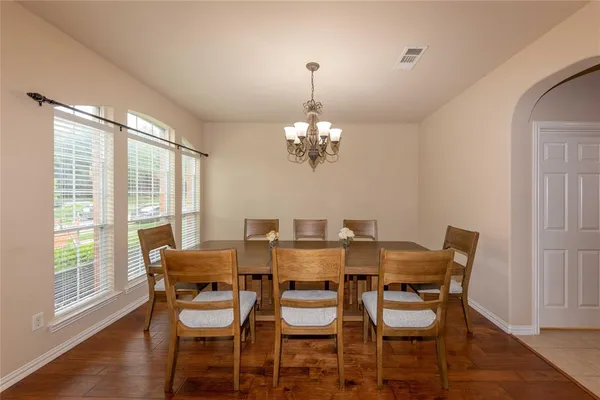 a dining room with furniture a chandelier and wooden floor