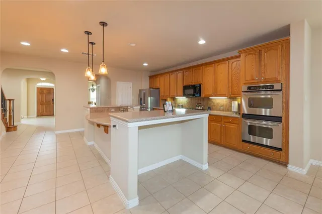 a kitchen with stainless steel appliances granite countertop a refrigerator a sink and a stove