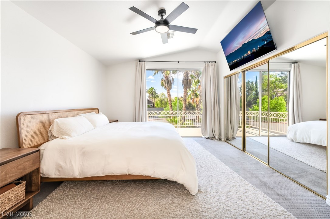 1941 Ivy Point Lane Las Vegas, NV 89134 - Photo 14 of 21 This naturally illuminated primary bedroom offers a private balcony with verdant outdoor views.