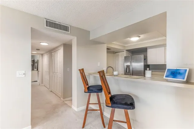 a kitchen with stainless steel appliances granite countertop a sink and a refrigerator