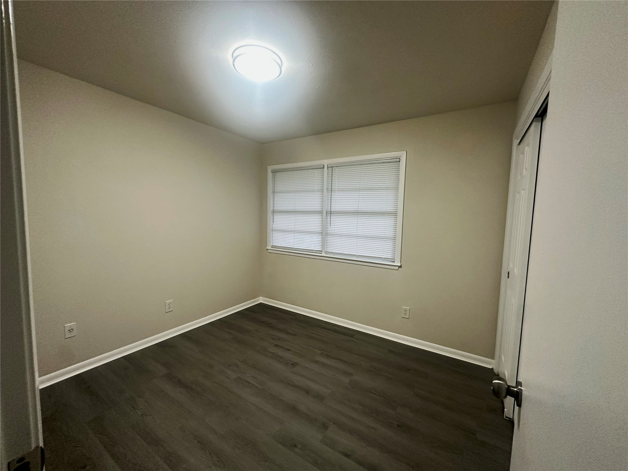 130 Bay Ridge Drive Baytown, TX 77523 - Photo 15 of 20 This room features neutral walls, flooring, a modern ceiling light, and a window with blinds, creating a simple yet functional space.