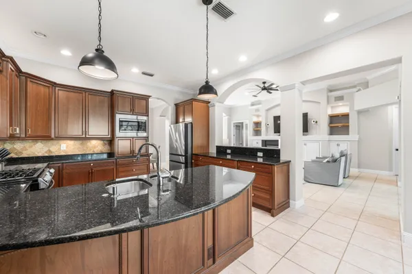 a kitchen with stainless steel appliances granite countertop a sink a stove and a wooden floors