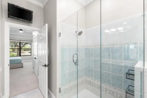 a bathroom with a shower and a flat screen tv