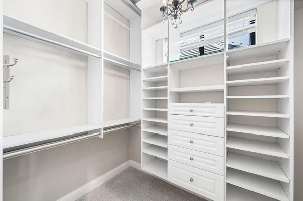 a view of walk in closet with empty racks
