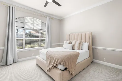 a large bed sitting in a bedroom next to a window