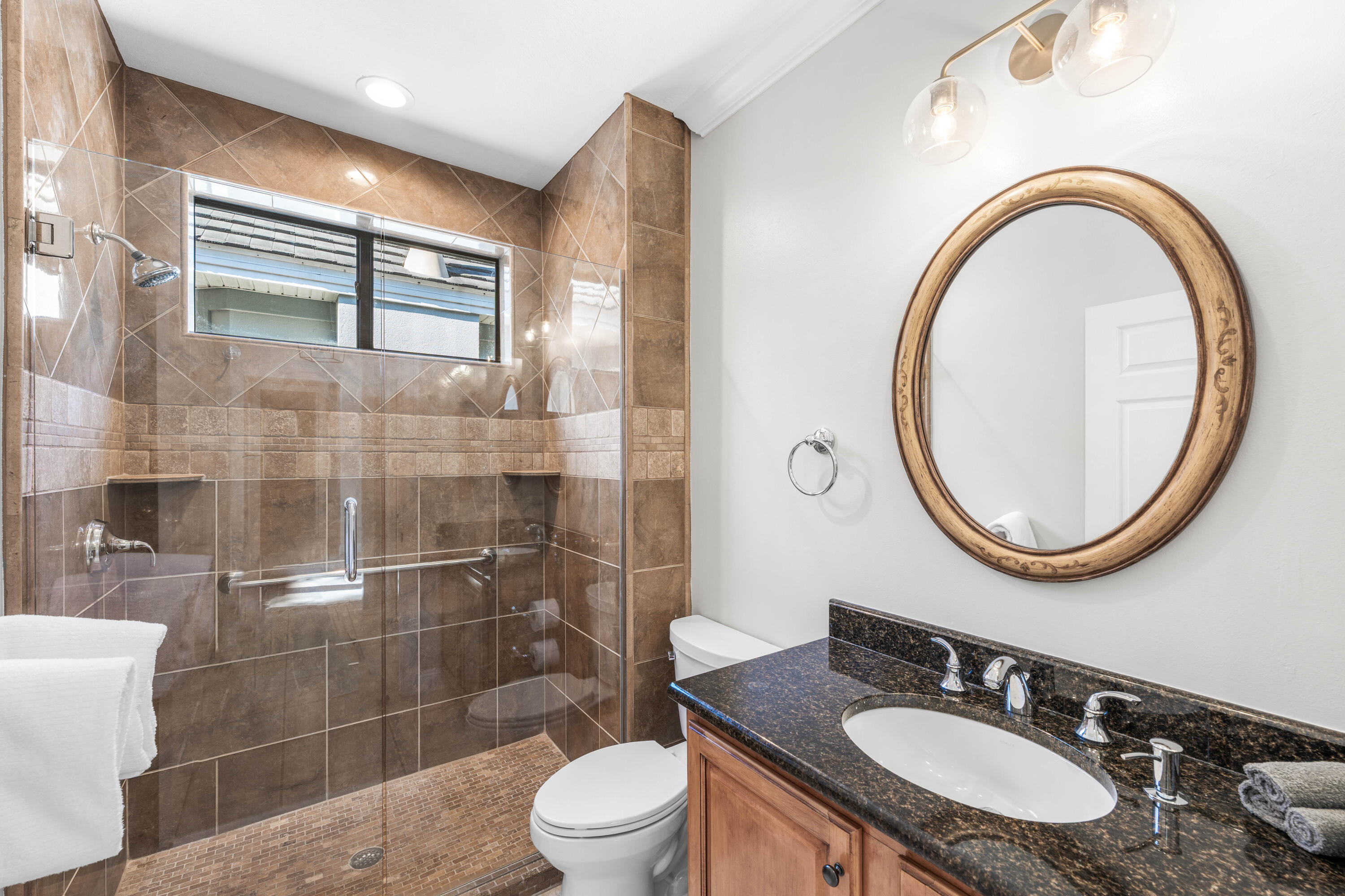 4345 Carriage Lane Destin, FL 32541 - Photo 28 of 39 a bathroom with a sink a mirror a toilet and shower