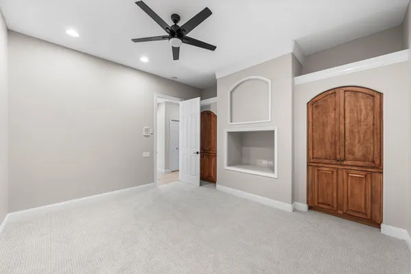 an empty room with closet and a ceiling fan