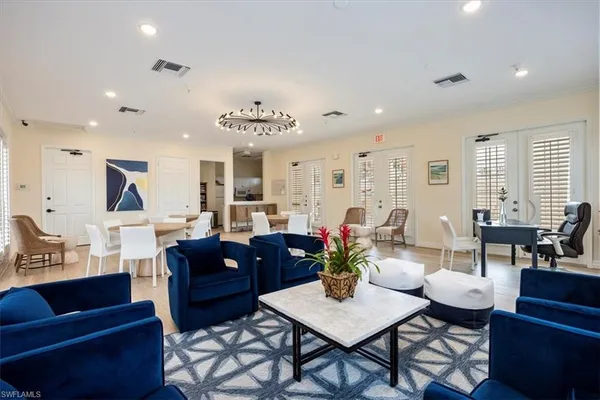 a living room with furniture kitchen view and a large window