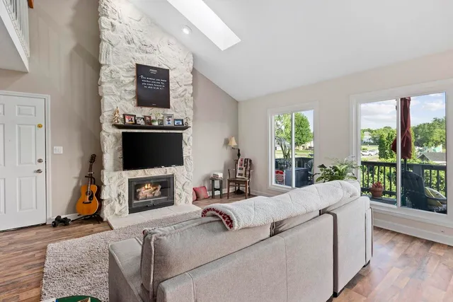 a living room with furniture a flat screen tv and a fireplace