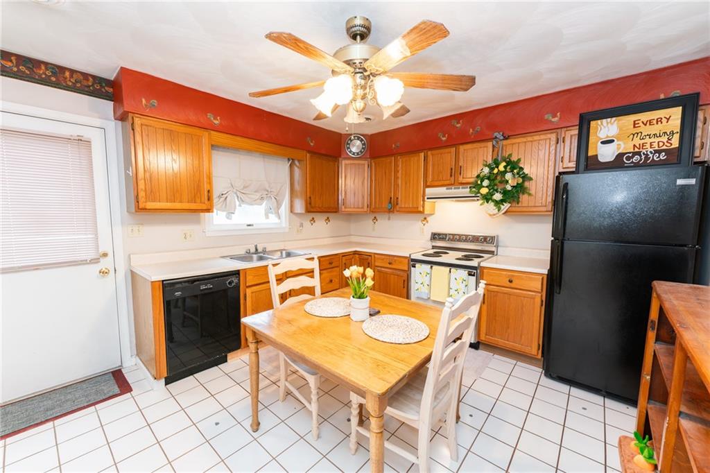 4903 Lucerne Road Indiana, PA 15701 - Photo 5 of 16 a kitchen with stainless steel appliances granite countertop a stove a refrigerator a sink a dining table and chairs with wooden floor