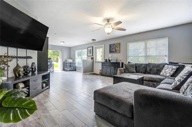 a living room with furniture a chandelier and a flat screen tv